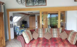 Bild 7: Blick vom Balkon in die zwei Wohnzimmerbereiche und rechts die Küche (hinter Glas)