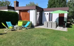 Ein Bungalow in einem Ferienpark, ganz in der Nähe vom Meer, Bild 1: Außenansicht des Gebäudes. Rückfassade